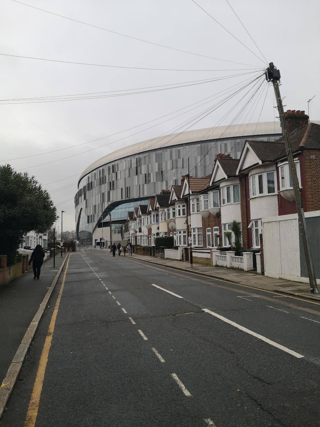 Tottenham Hotspur Stadium rising above a quiet residential street in North London