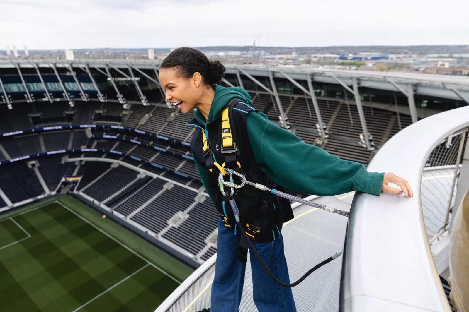 Skywalk visitor leaning over the edge of the Tottenham Hotspur Stadium roof